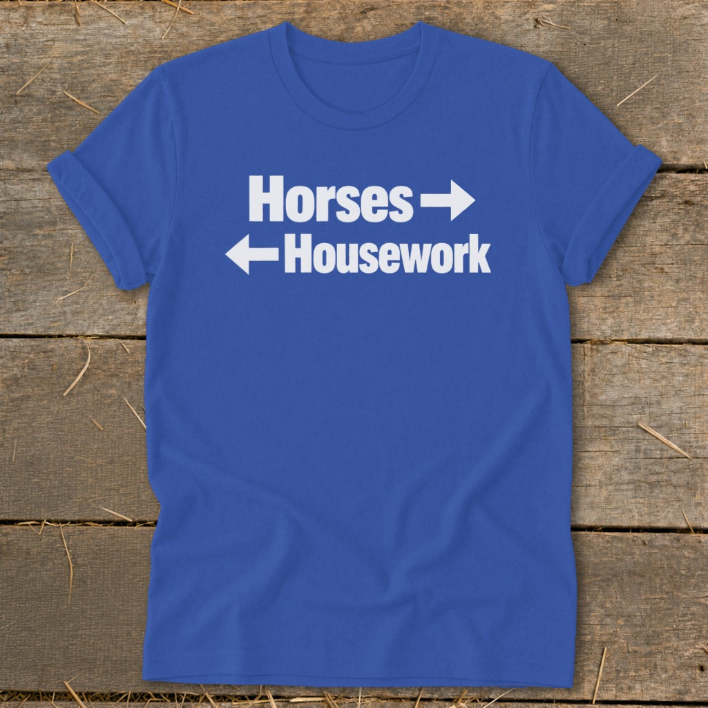 Blue t-shirt featuring white text that reads Horses with a right arrow and Housework with a left arrow.