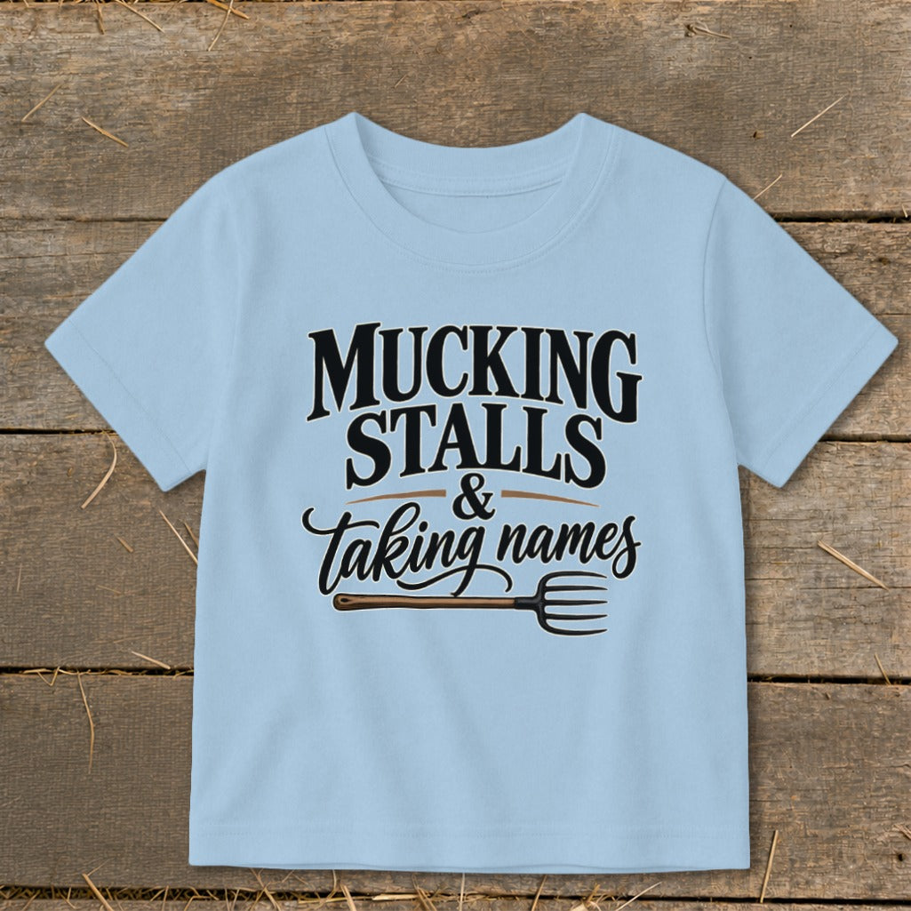 Light blue t-shirt with "Mucking Stalls & Taking Names" and pitchfork graphic.
