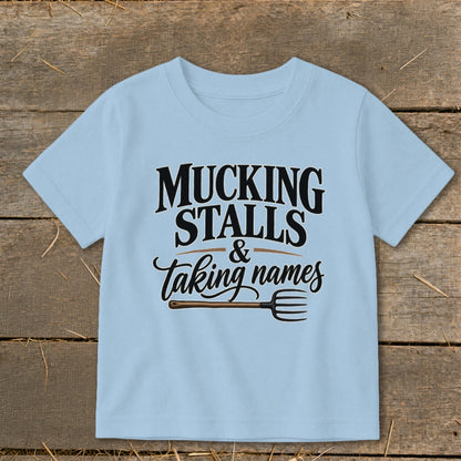 Light blue t-shirt with "Mucking Stalls & Taking Names" and pitchfork graphic.