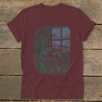 T-shirt with illustration of a cat sleeping in hay by a window.