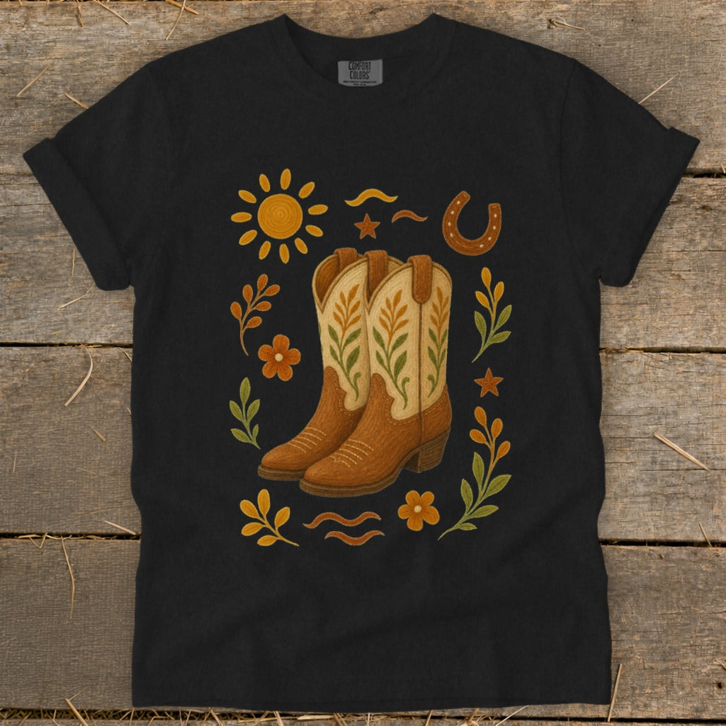 Black t-shirt with cowboy boots, sun, horseshoe, and floral design.