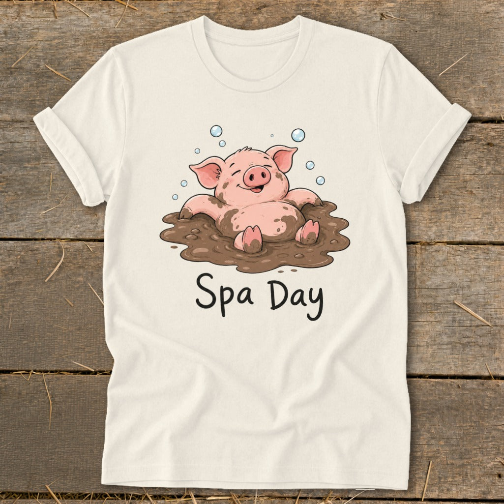 Cream t-shirt with cartoon pig relaxing in mud, with "Spa Day" text below.