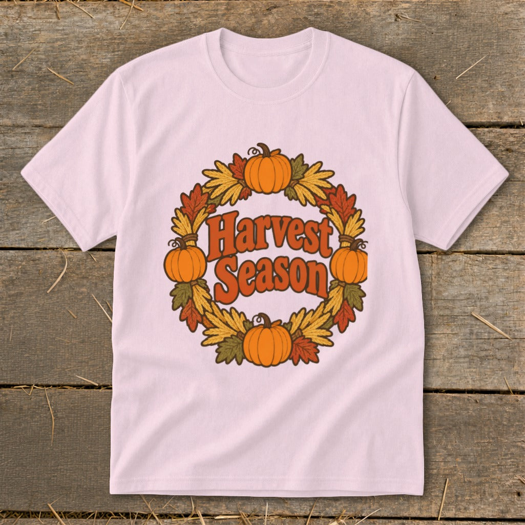 Pink t-shirt with a circular harvest wreath design featuring pumpkins and leaves, and the text "Harvest Season".