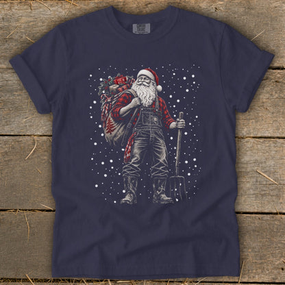 Santa in overalls and plaid shirt holds pitchfork and sack of gifts, with snow falling.