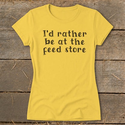 Yellow t-shirt with black text that reads "I'd rather be at the feed store."