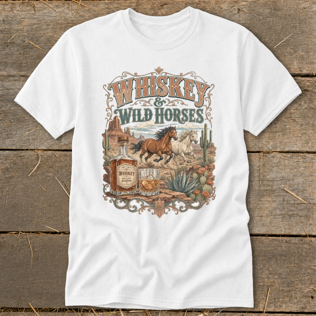 White t-shirt with "Whiskey & Wild Horses" text, horses, whiskey bottle, and desert landscape.