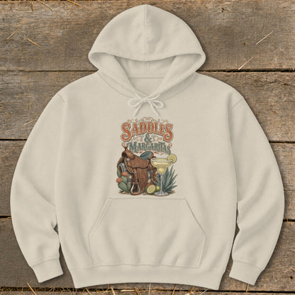 Cream hoodie with "Saddles & Margaritas" graphic, including a saddle, cacti, and margarita.