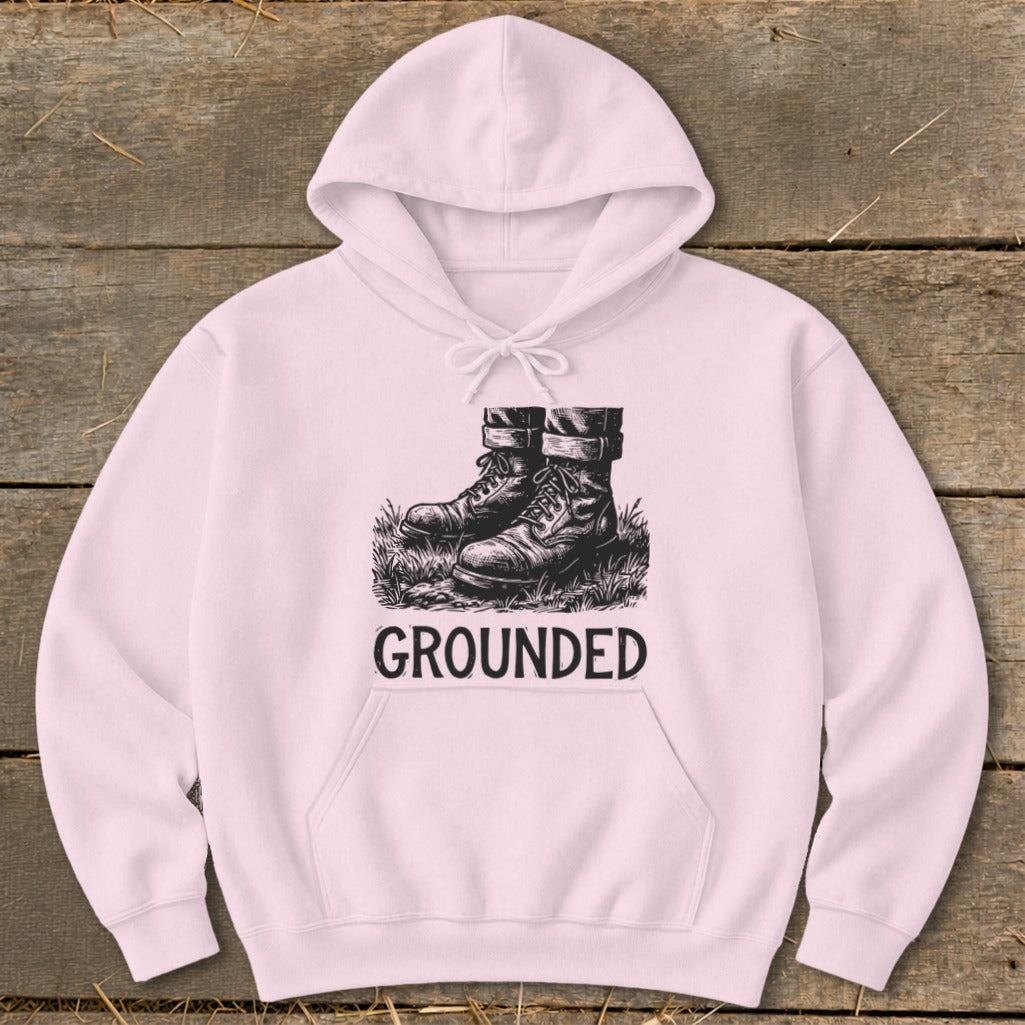Pink hoodie with "GROUNDED" text and a graphic of boots in grass.