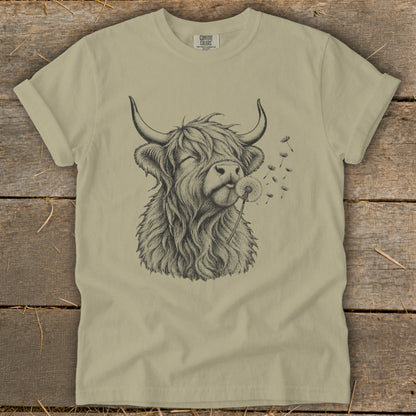 T-shirt with a sketch of a Highland cow blowing a dandelion.