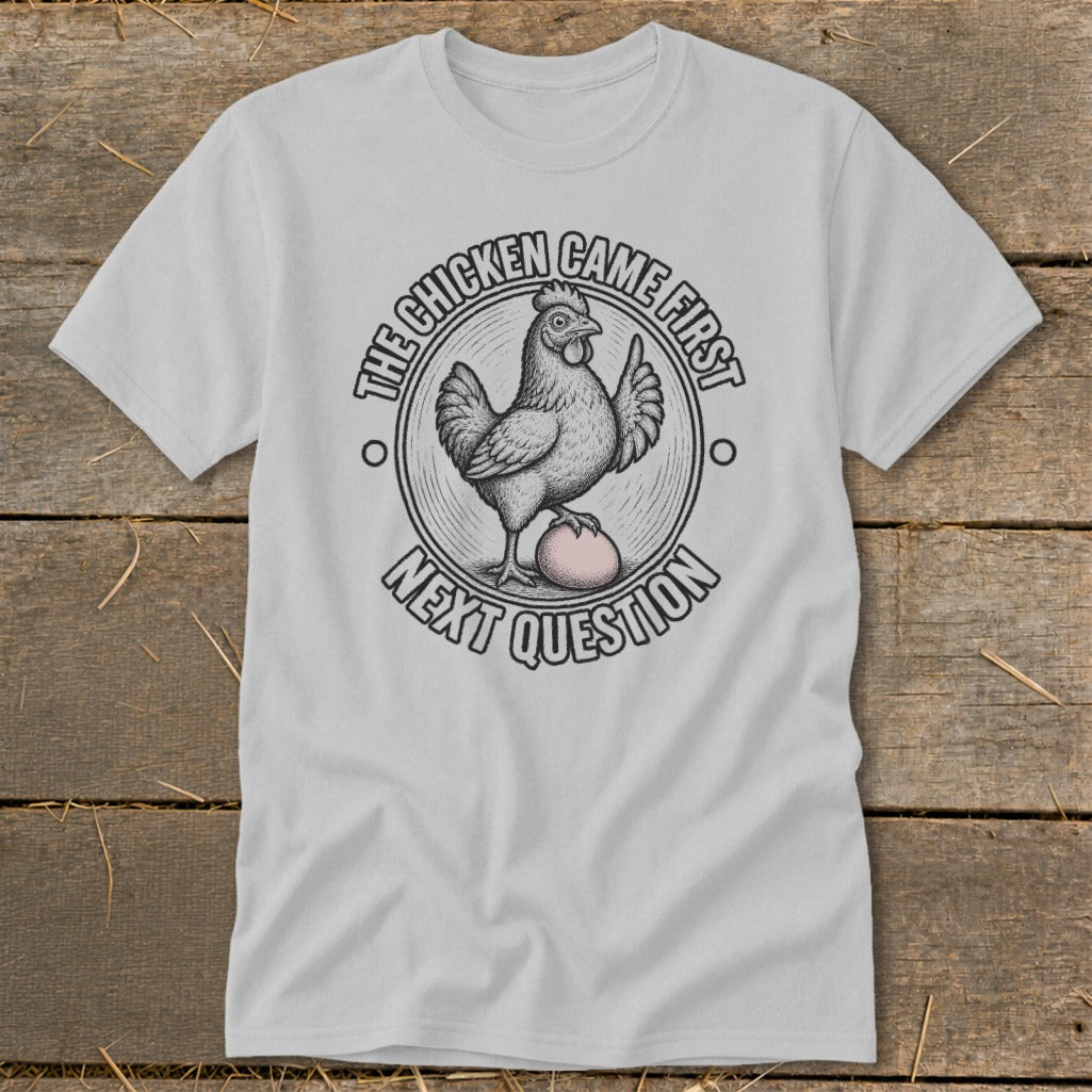 Light gray t-shirt with graphic of chicken and egg and text "The Chicken Came First, Next Question".