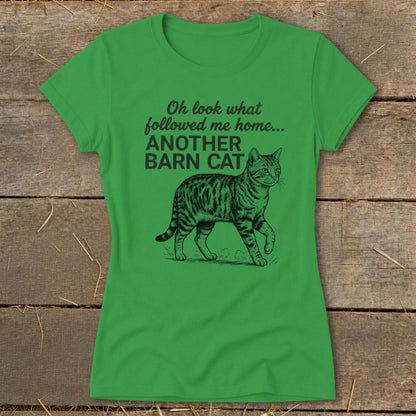 Green t-shirt with black text "Oh look what followed me home... ANOTHER BARN CAT" and cat illustration.
