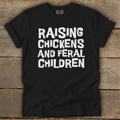 Black t-shirt with white text "Raising Chickens and Feral Children".