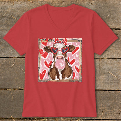 Cow with heart sunglasses chewing bubblegum, wearing a red bow.