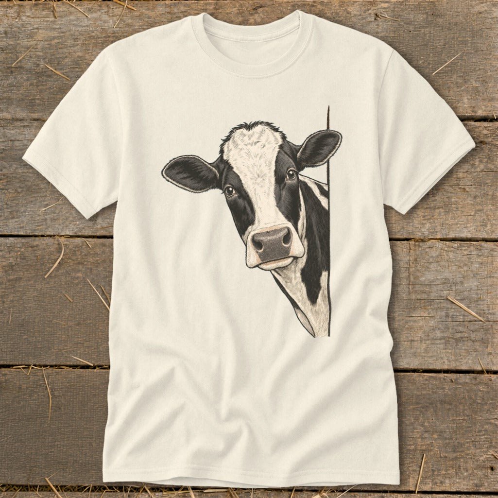 Black and white cow peeking from the side on a cream t-shirt.