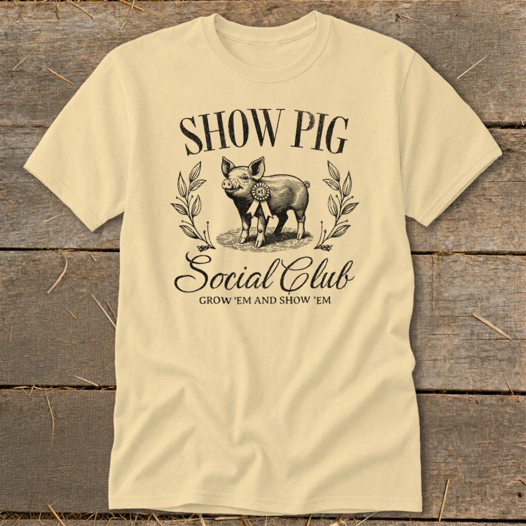 Cream t-shirt with "Show Pig Social Club" text and a pig with a ribbon.
