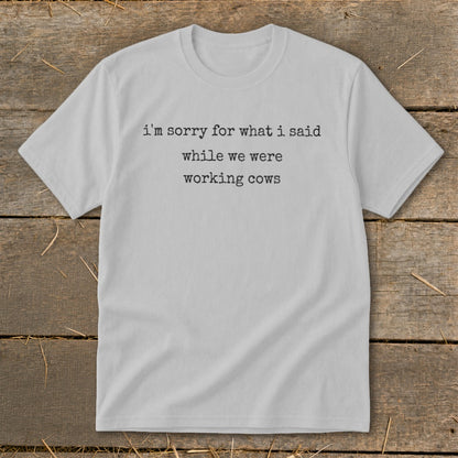 Light gray t-shirt with black text that reads "i'm sorry for what i said while we were working cows."