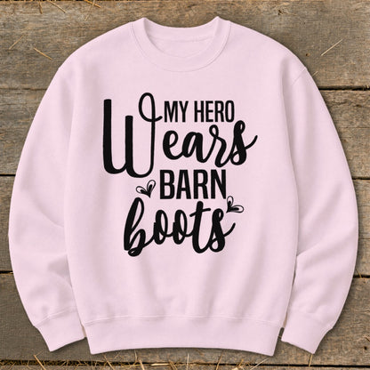 Pink sweatshirt with black text reading "My hero wears barn boots".