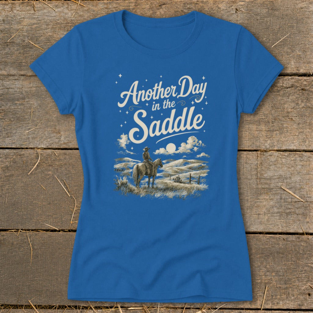 Blue t-shirt with "Another Day in the Saddle" text and cowboy on horse illustration.