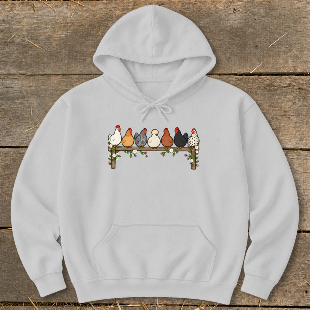 Light gray pullover hoodie featuring an illustrated graphic of seven diverse chickens perched on a flower-decorated wooden fence.