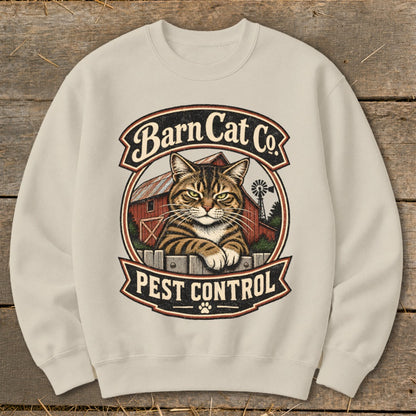 Cream-colored crewneck sweatshirt featuring a graphic of a tabby cat behind a fence with a barn and Barn Cat Co. Pest Control text.