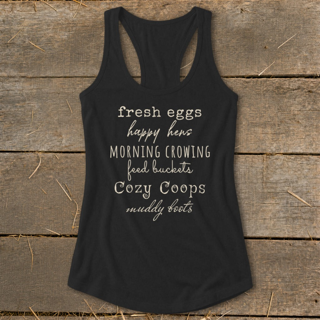 Black tank top with white text: "fresh eggs happy hens MORNING CROWING feed buckets Cozy Coops muddy boots"