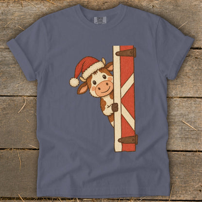 Cartoon cow in Santa hat peeking from behind a red barn door.