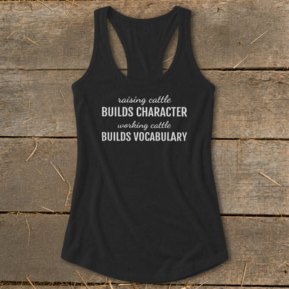 Black tank top with white text: "raising cattle BUILDS CHARACTER working cattle BUILDS VOCABULARY."