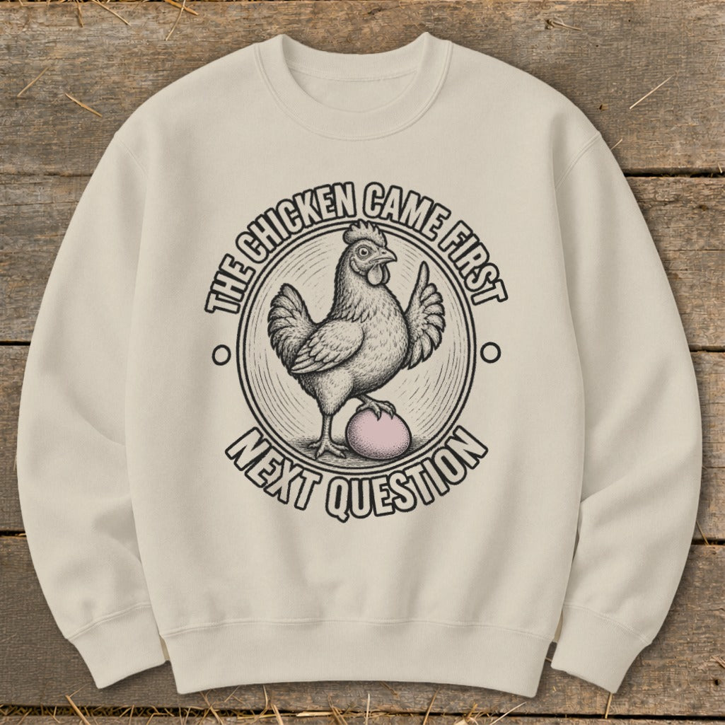 Crewneck sweatshirt with chicken and egg graphic and "The chicken came first. Next question" text.