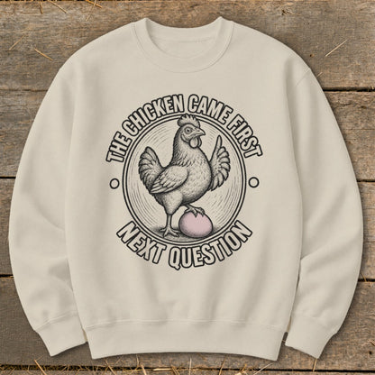Crewneck sweatshirt with chicken and egg graphic and "The chicken came first. Next question" text.