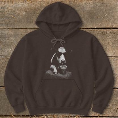 Brown hoodie with a black and white graphic of a cow drinking from a cup.
