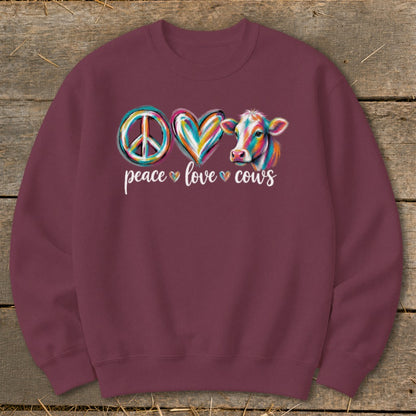 Maroon sweatshirt with colorful peace sign, heart, and cow graphic and text.
