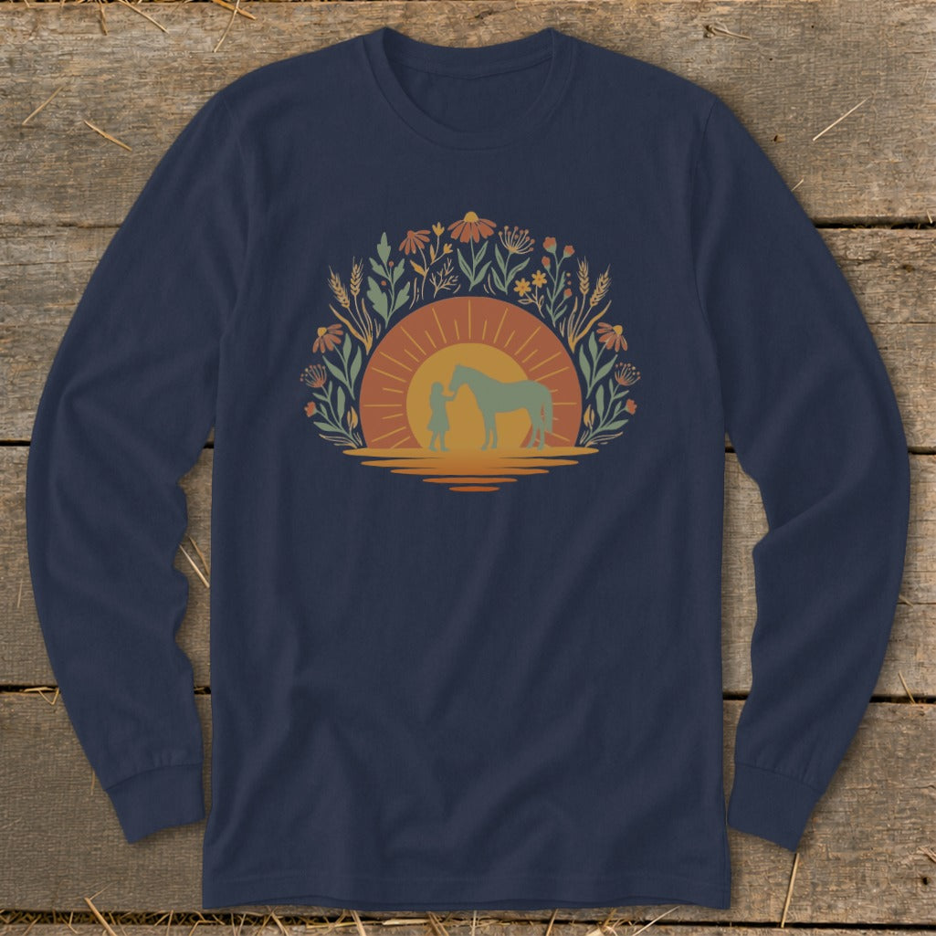 Girl and horse silhouetted at sunset surrounded by wildflowers on a navy long-sleeve shirt.