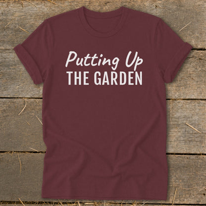 Maroon t-shirt with white text reading "Putting Up THE GARDEN".