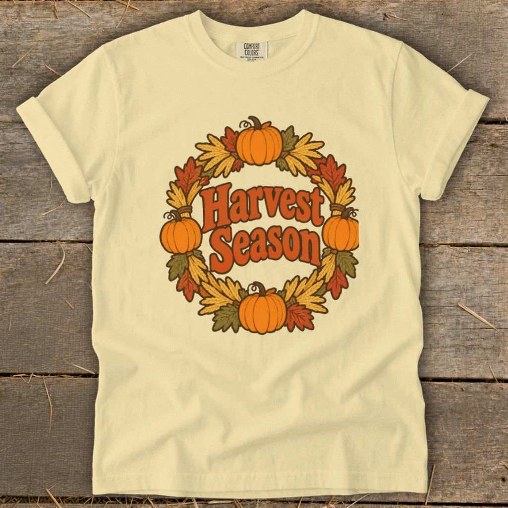Cream t-shirt with "Harvest Season" text in a circular pumpkin and leaf wreath.