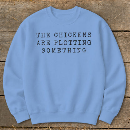 Light blue sweatshirt with "The chickens are plotting something" text.