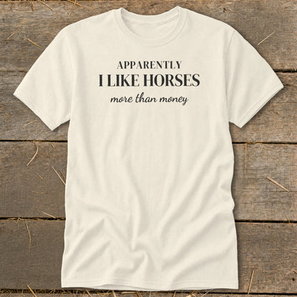 Cream t-shirt with black text that reads "APPARENTLY I LIKE HORSES more than money".