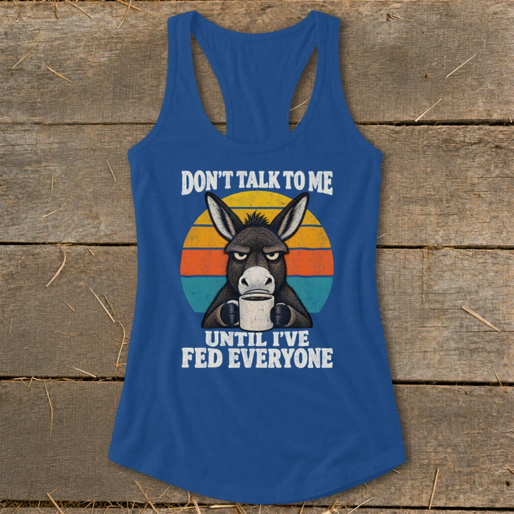 Blue women's racerback tank top featuring a grumpy donkey holding a coffee mug with retro text.