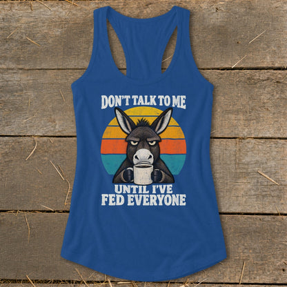 Blue women's racerback tank top featuring a grumpy donkey holding a coffee mug with retro text.