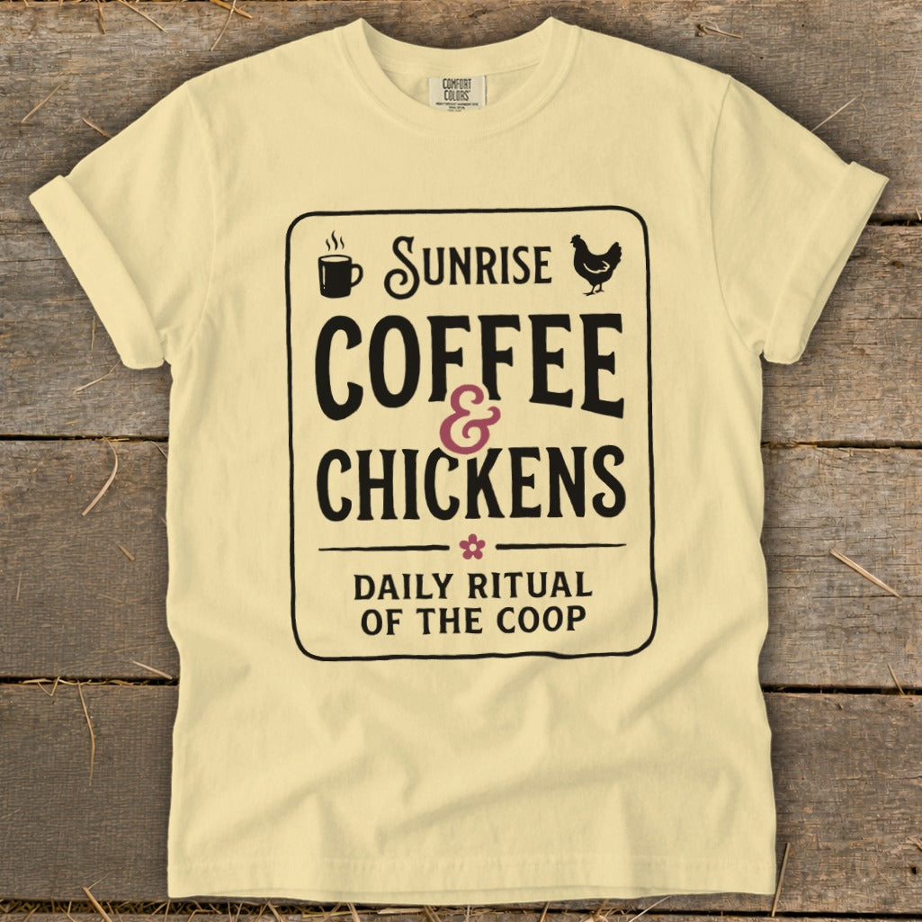 Light yellow t-shirt with black text: Sunrise coffee & chickens, daily ritual of the coop.