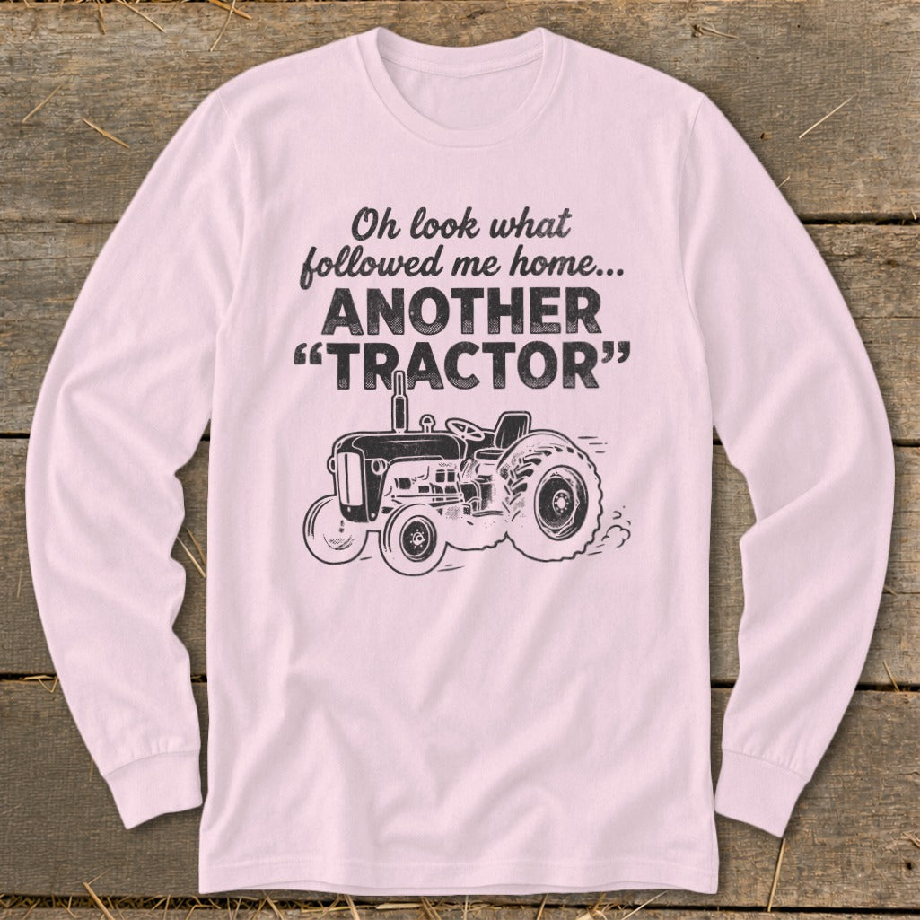 Long sleeve shirt with black graphic of tractor and text: "Oh look what followed me home... ANOTHER 'TRACTOR'".