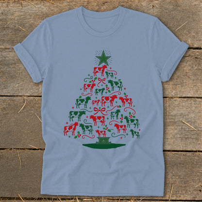 Light blue t-shirt with a Christmas tree made of red and green cows and holly.