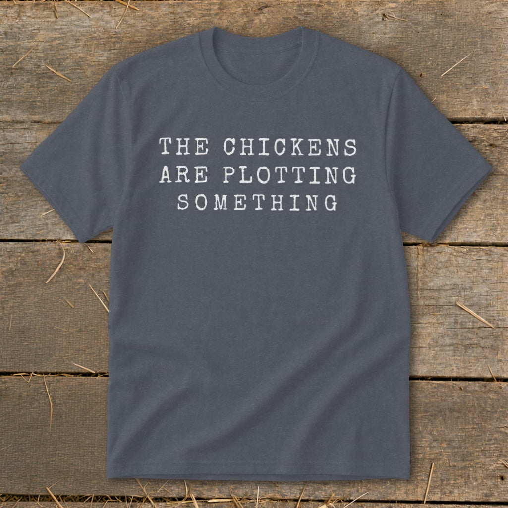 Gray t-shirt with white text that reads "THE CHICKENS ARE PLOTTING SOMETHING".