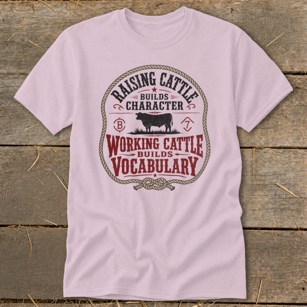 Pink t-shirt with a rustic design reading "Raising Cattle Builds Character, Working Cattle Builds Vocabulary."