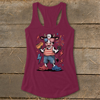 Cartoon cow in American flag outfit holding a hot dog and a firework.
