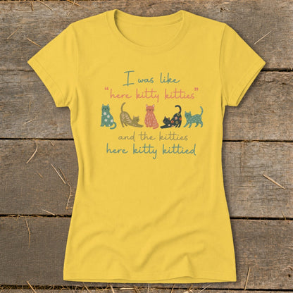 Yellow t-shirt with colorful cats and text "I was like 'here kitty kitties' and the kitties here kitty kittied."