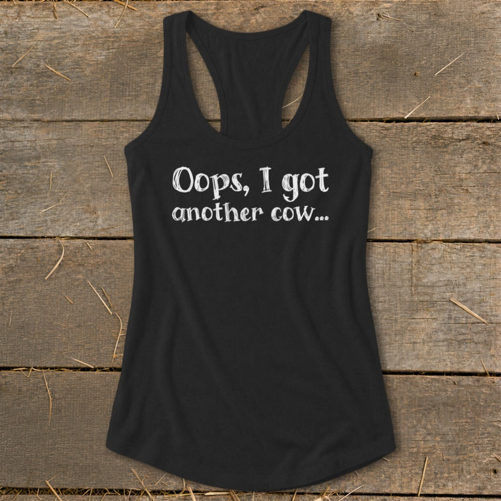 Black racerback tank top with white text that reads "Oops, I got another cow..."