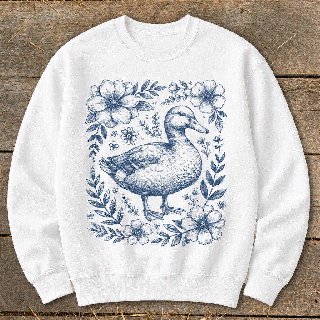 White sweatshirt with a blue line drawing of a duck surrounded by flowers.