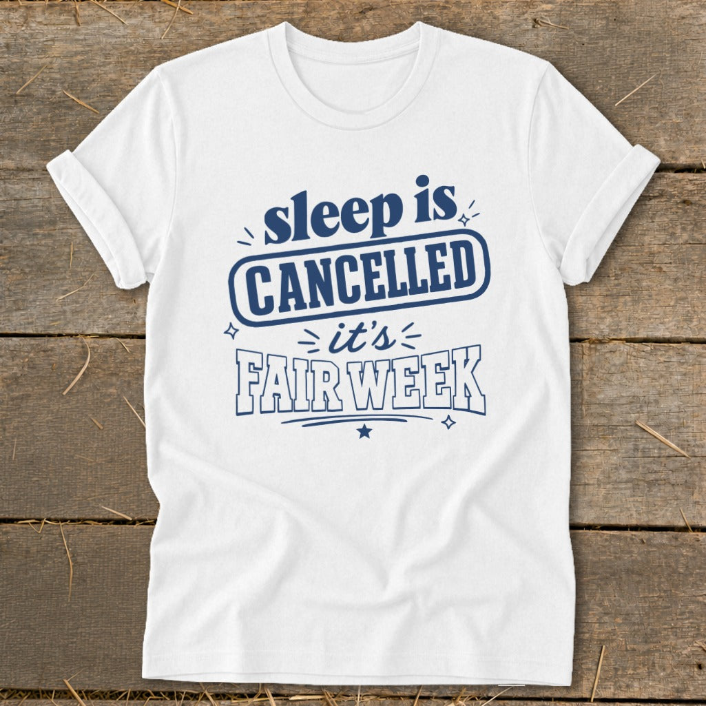 White t-shirt with blue text reading "sleep is CANCELLED it's FAIR WEEK".