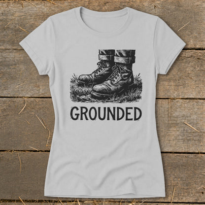 Light grey t-shirt with black graphic of boots in grass and text "GROUNDED".