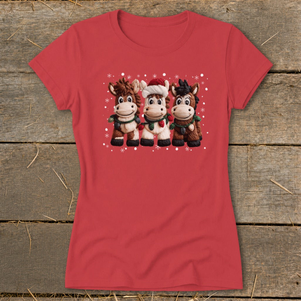 Red t-shirt with a Christmas graphic of three cartoon horses wearing scarves and garlands.